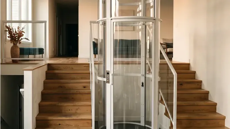 A round clear pneumatic vacuum home elevator tube standing in the stairwell of a modern home